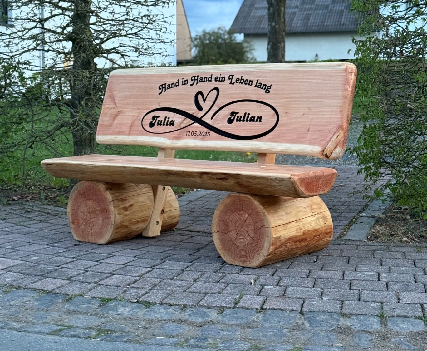 Holzbank mit Gravur – rustikale Gartenbank aus Baumstämmen mit Namensgravur im Garten